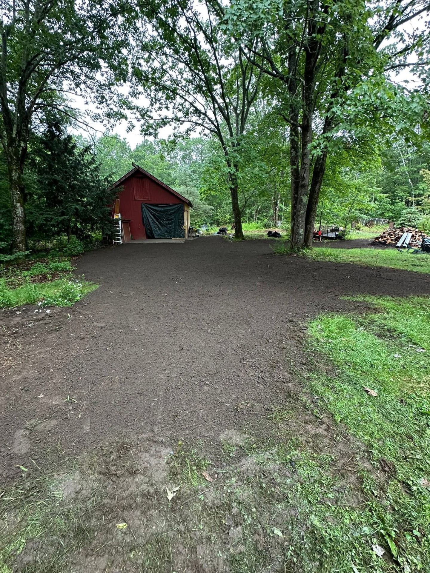 Freshly graded loam in front of the red barn, ready for seed