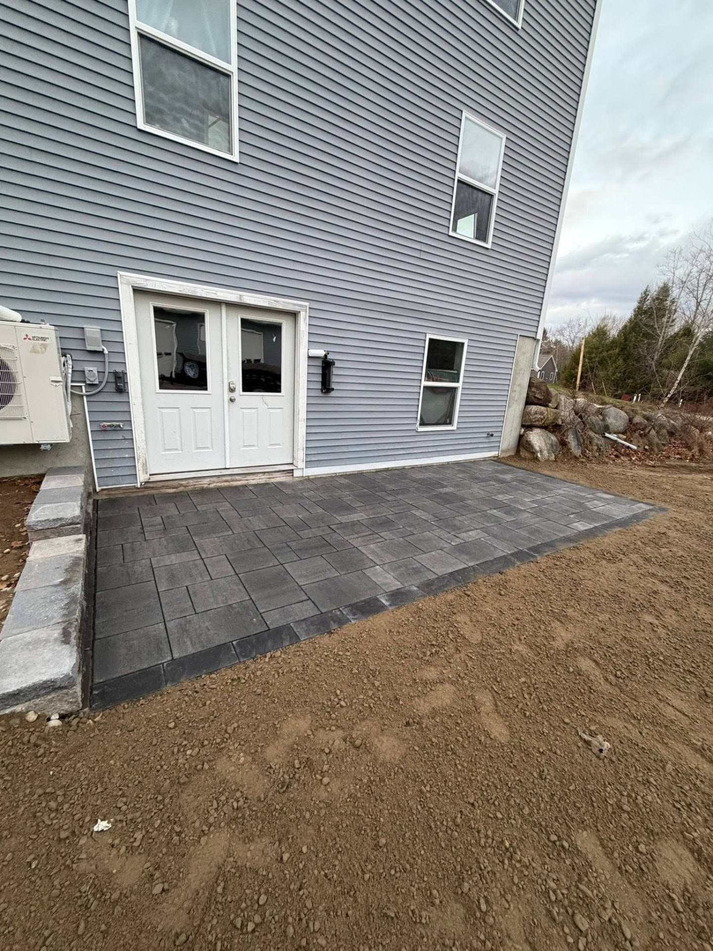 Finished paver patio and walkway with a stone border